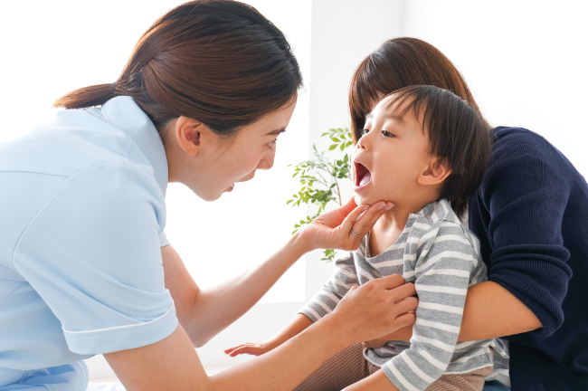 子供の歯を見ている医師