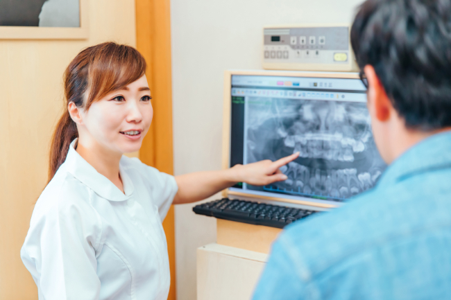 歯の根の治療について説明している女性